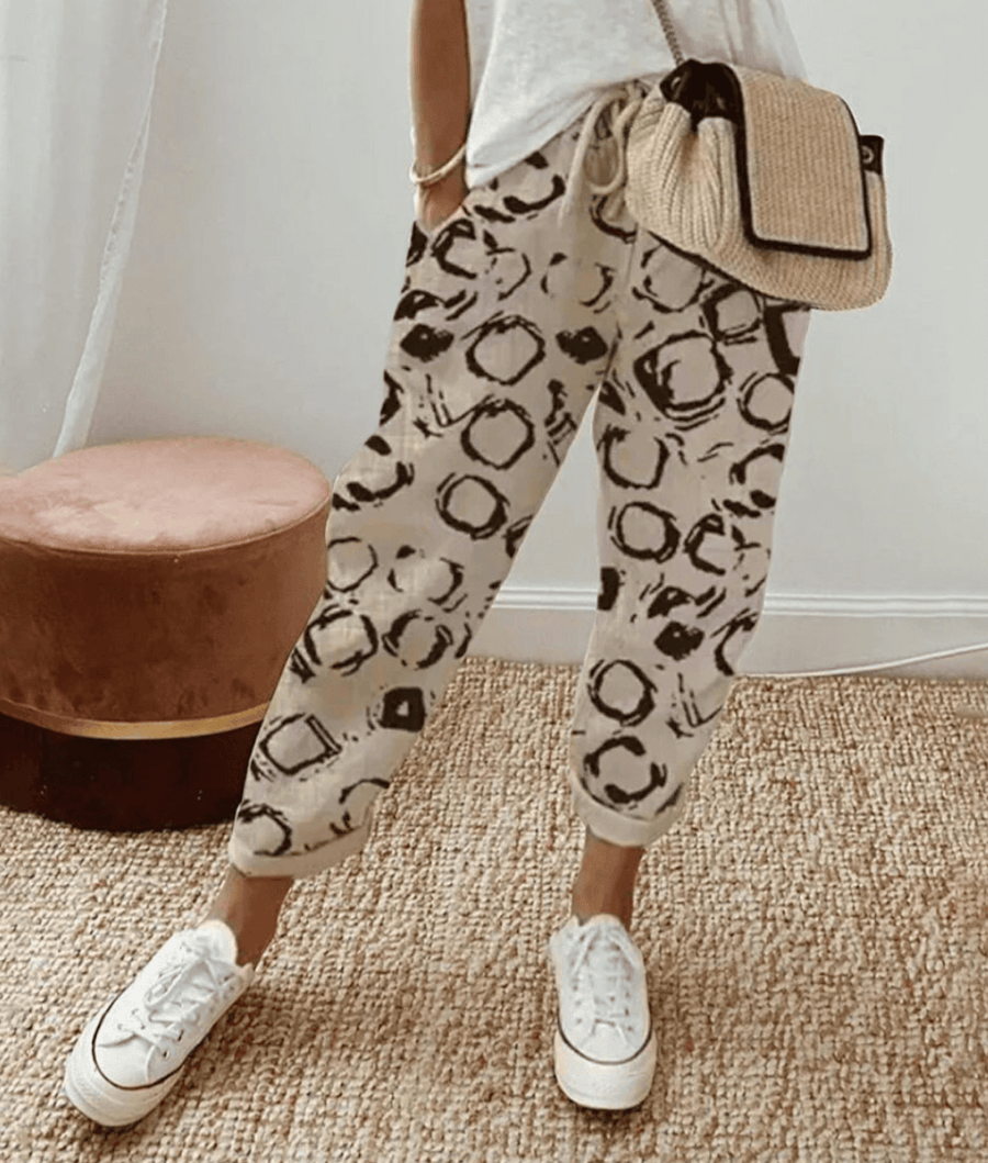 Beige cotton trousers with black circular print, elastic waist and cuffed hems
