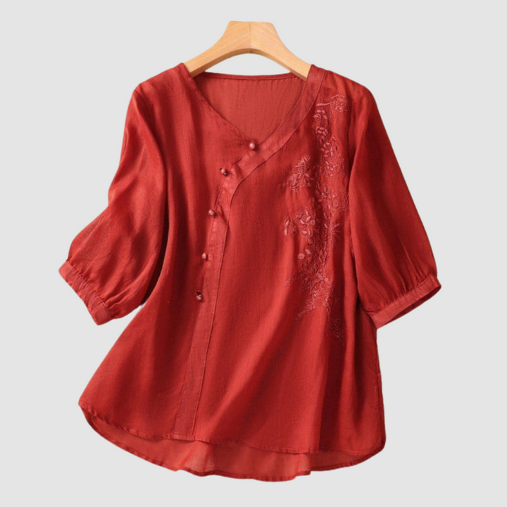 Red breathable blouse with V-neck, button front, short sleeves, and embroidered chest detail