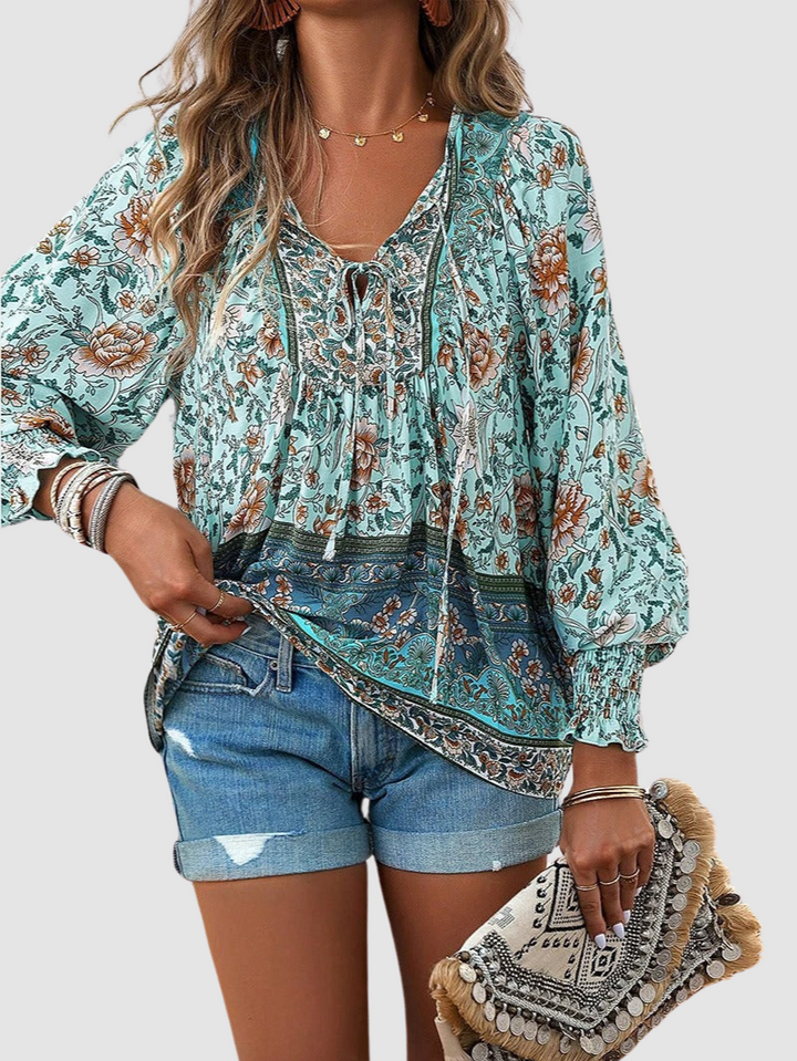 Teal floral peasant blouse with V-neck tie, smocked yoke, and long puff sleeves.