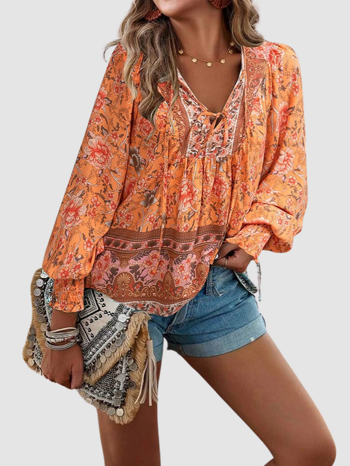 Orange floral peasant blouse with tie-neck, gathered yoke, and puff sleeves