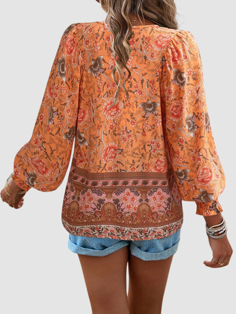 Orange floral blouse back view with keyhole tie neckline and long puff sleeves