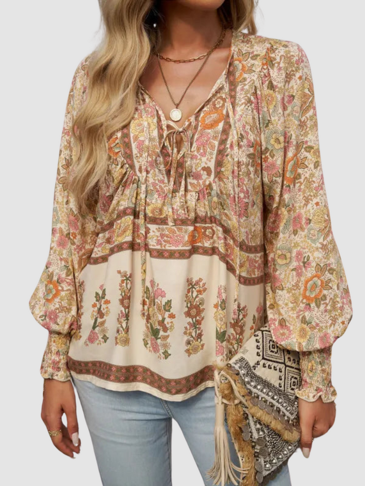 Cream floral blouse with tie-neck, ruffled yoke, and long puff sleeves
