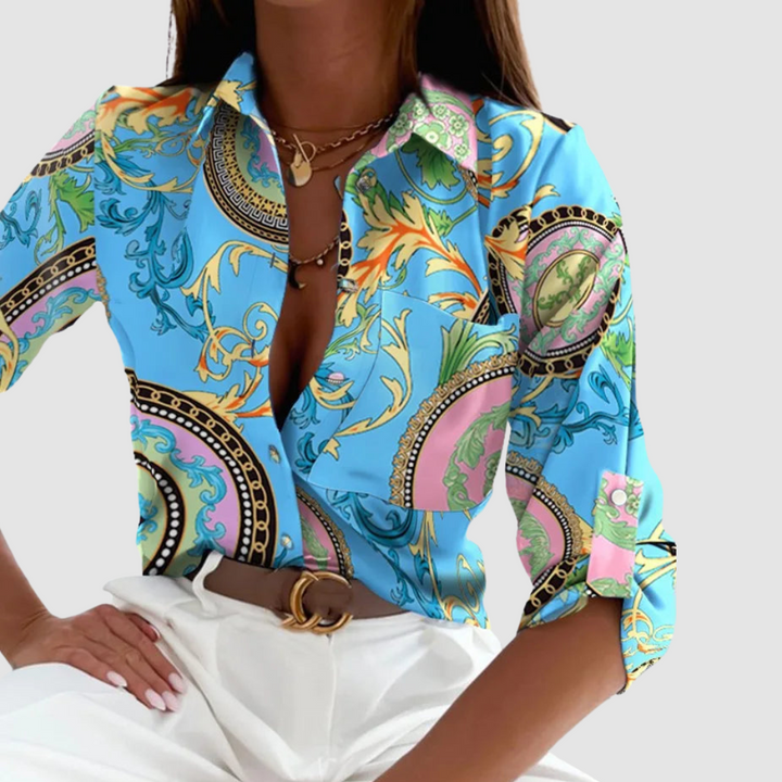 Chic pocket blouse in bright blue with ornate multicolor print, button-front long sleeves