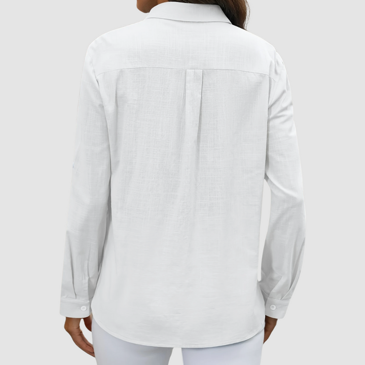 White pocket blouse with long sleeves and center-back yoke seam, button-front style