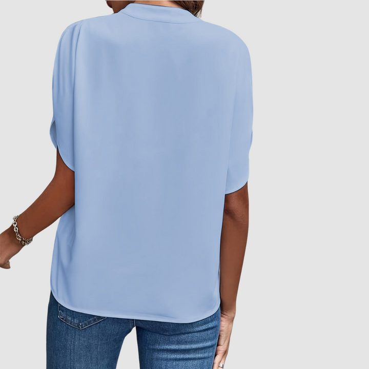 Blue draped blouse back view with short dolman sleeves and relaxed fit
