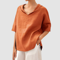 Orange short-sleeve blouse with V-neck and loose, draped fit.