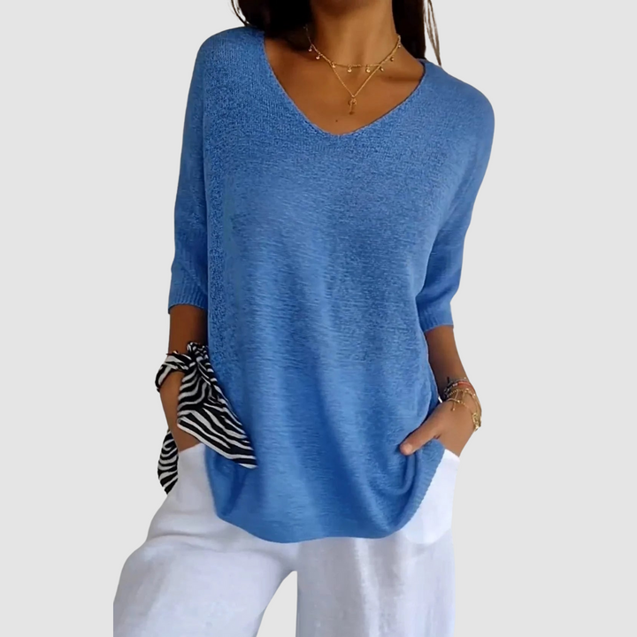Blue knit V-neck top with three-quarter sleeves, loose fit and curved hem