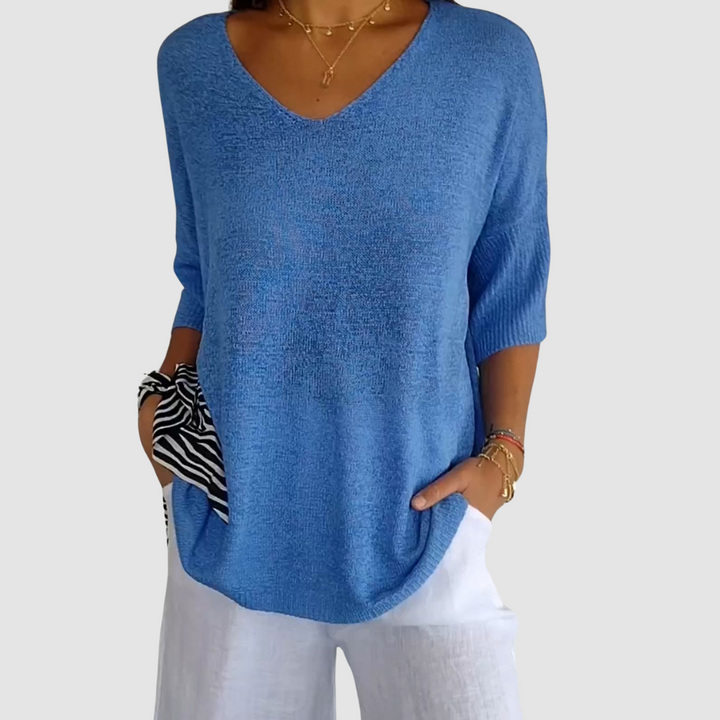 Blue knit V-neck top with three-quarter sleeves and relaxed drape fit