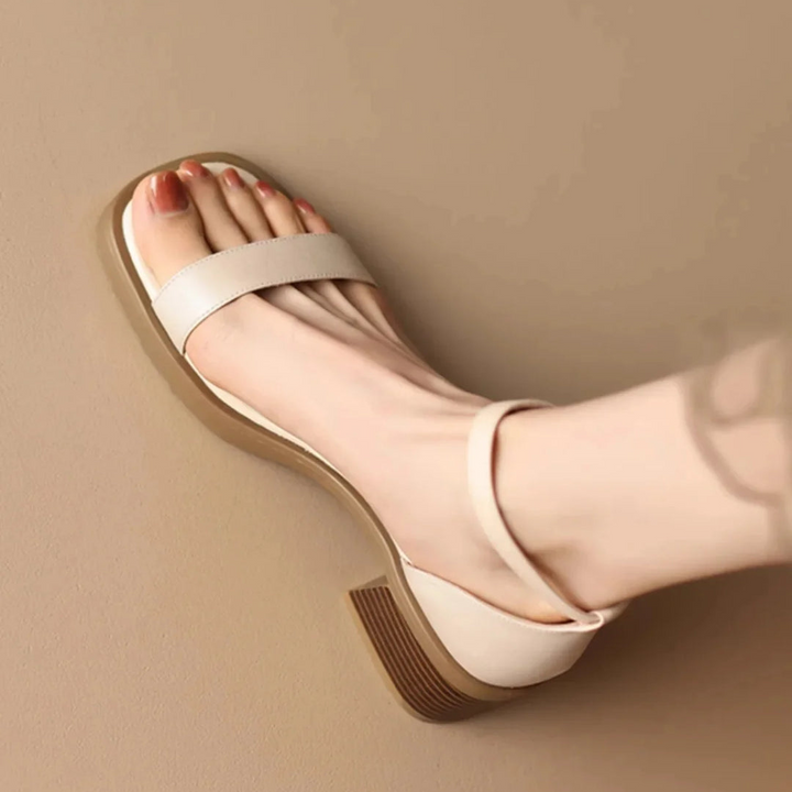 Light beige leather slide sandals with wide toe strap and low wedge sole