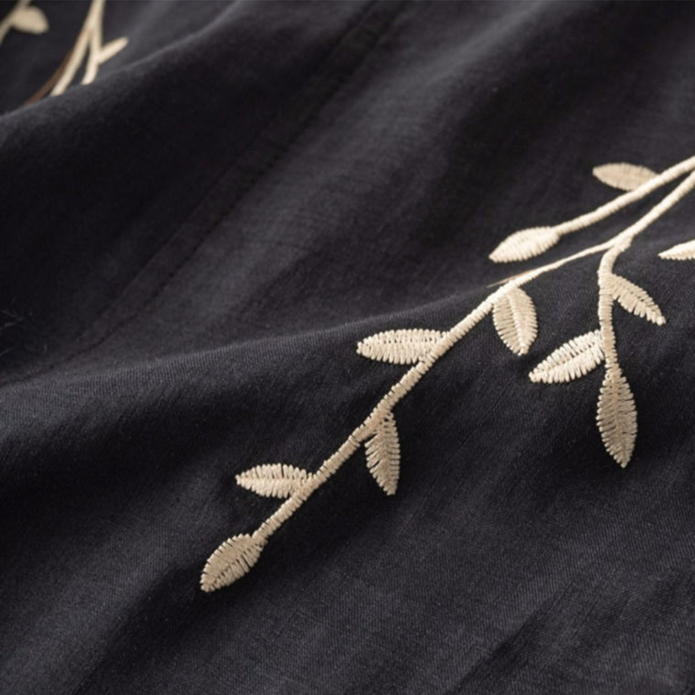 Dark cotton-linen top fabric with cream leaf embroidery detail along the chest