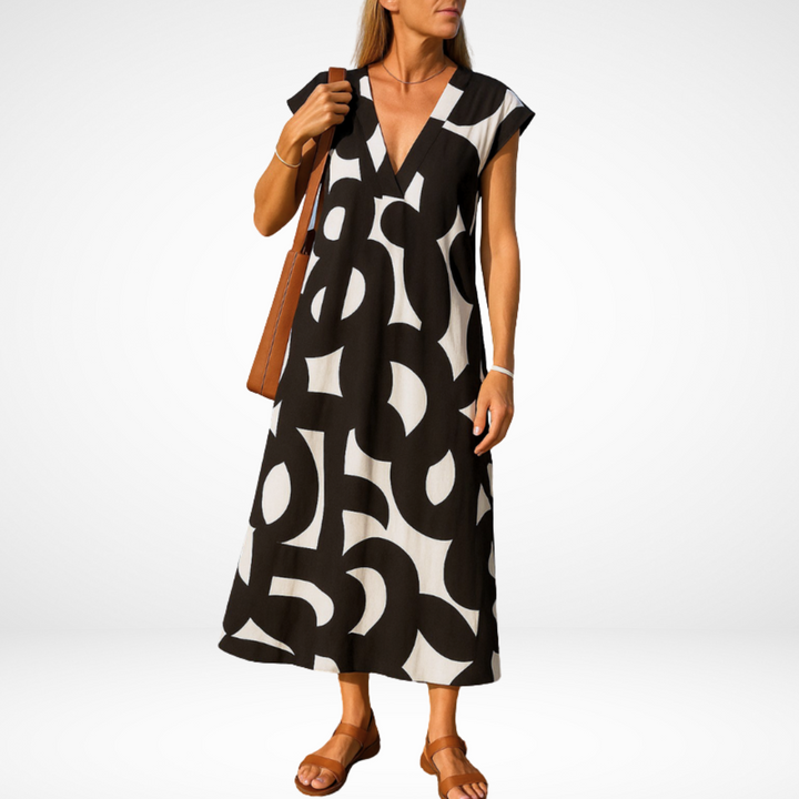 Black flowy V-neck midi dress with abstract white shapes, short cap sleeves.