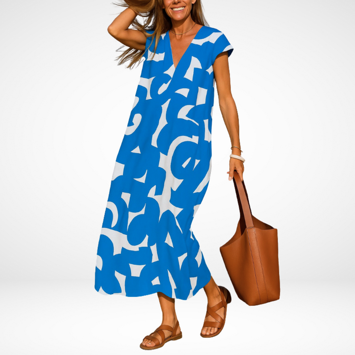 Blue flowy V-neck midi dress with abstract white shapes, short cap sleeves.