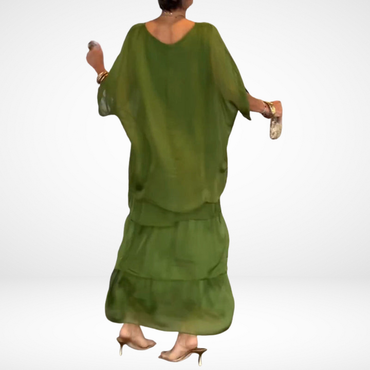 Back view of green loose maxi dress with tiered skirt and drapey dolman sleeves.