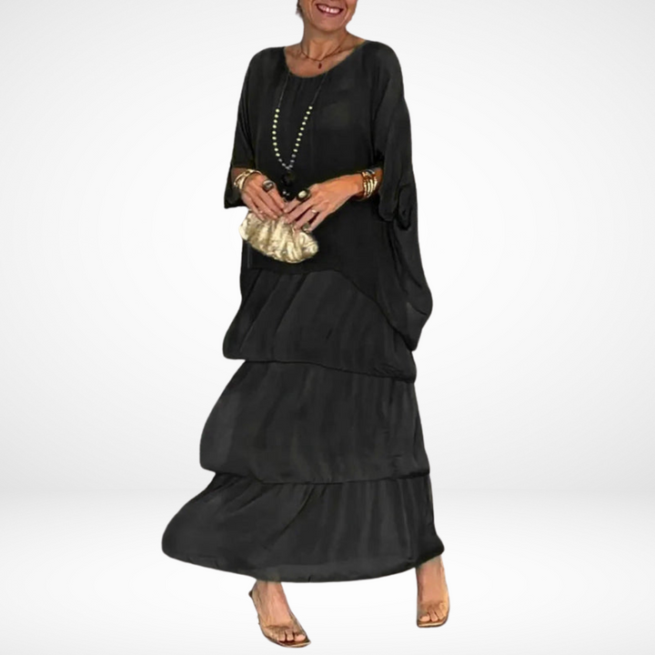 Black loose maxi dress with tiered skirt, drapey dolman sleeves, scoop neckline.