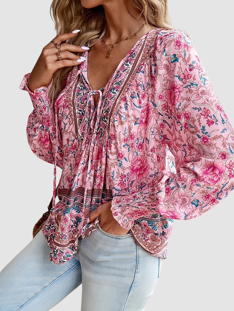 Pink floral peasant blouse with V-neck tie and billowy long puff sleeves, tassel hem
