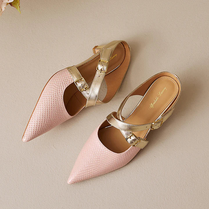 Pink textured leather slip-on mule with gold buckled straps and pointed toe.