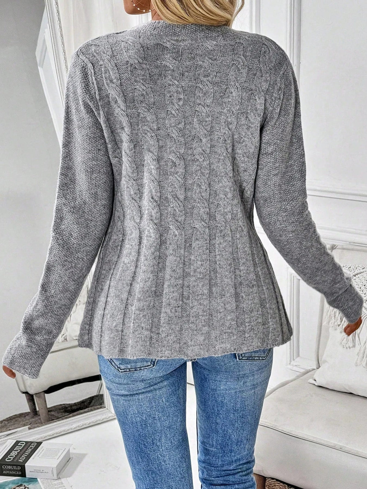 Back view of gray ribbed cardigan with button placket and peplum hem