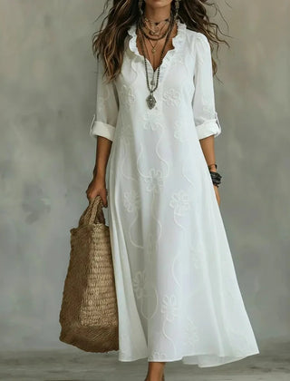White maxi dress with short sleeves and subtle floral pattern, V-neck.