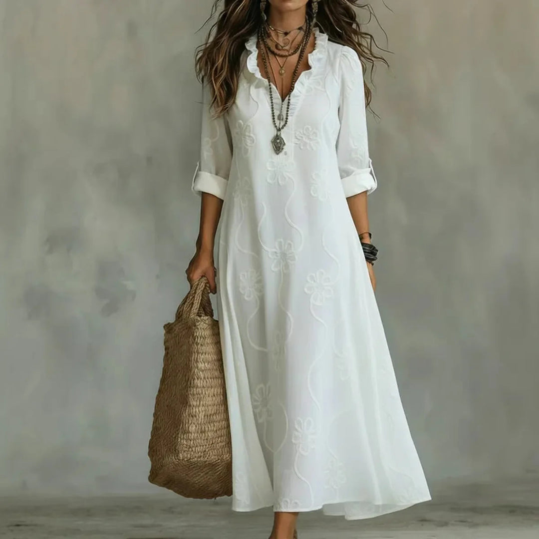 White maxi dress with short sleeves and subtle floral pattern, V-neck.