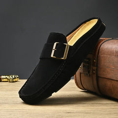 Black suede mules with square metal buckle strap and cushioned sole, slip-on