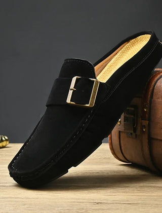 Black suede mules with square metal buckle strap and cushioned sole, slip-on