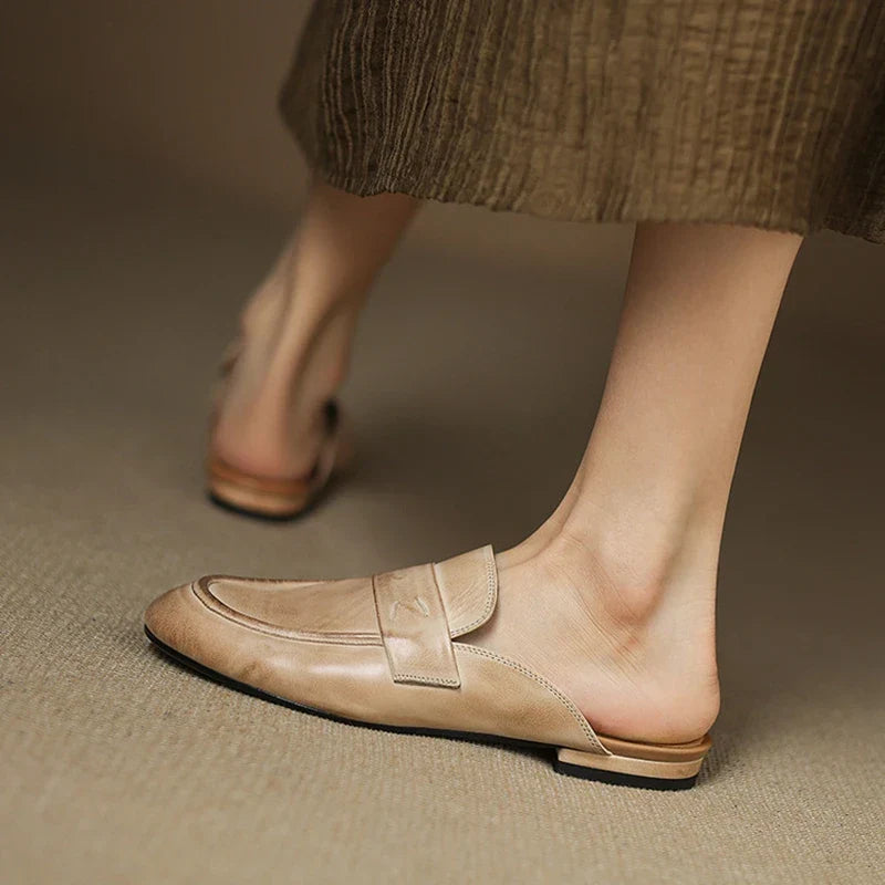 Beige leather mule with square toe slip-on design and strap across the top