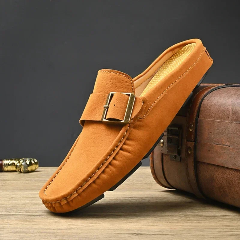 Tan suede mules with square buckle strap and moc-toe stitching
