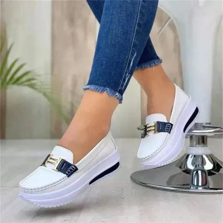 Sleek orthopedic loafers, white slip-on with buckle strap and white sole.