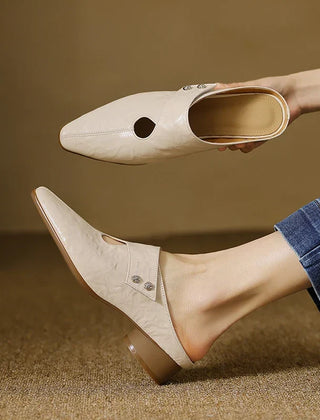 Beige leather mules with pointed toe, side cutout, and low heel