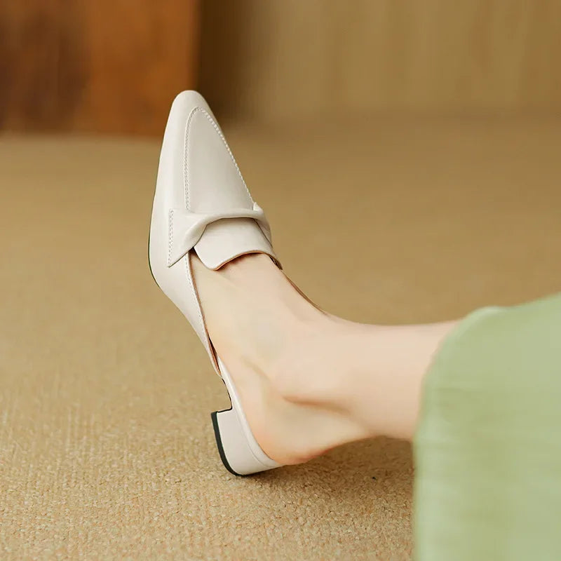 Beige mule with pointed toe, slip-on upper, and low block heel detail