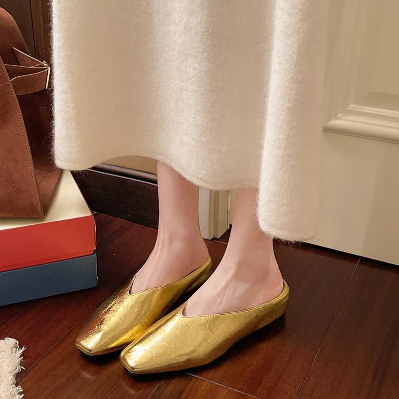 Gold metallic mule flats with pointed toe and low block heel, on-foot view