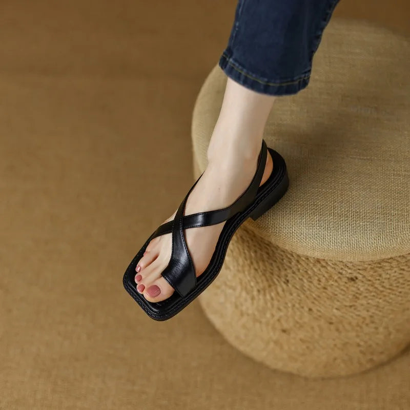 Black leather thong sandals with wide T-strap and flat sole