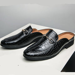 Black croc-textured leather mules pair on white surface, low black block heel