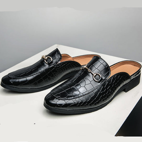 Black croc-textured leather mules pair on white surface, low black block heel