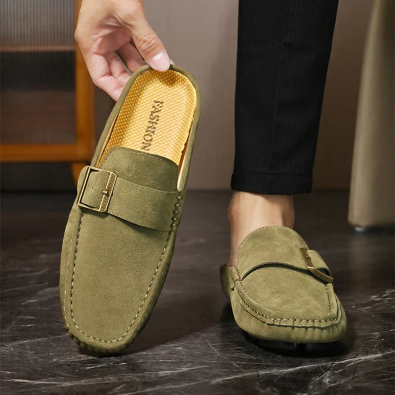 Olive green suede mules with square metal buckle and stitched moc toe, slip-on style