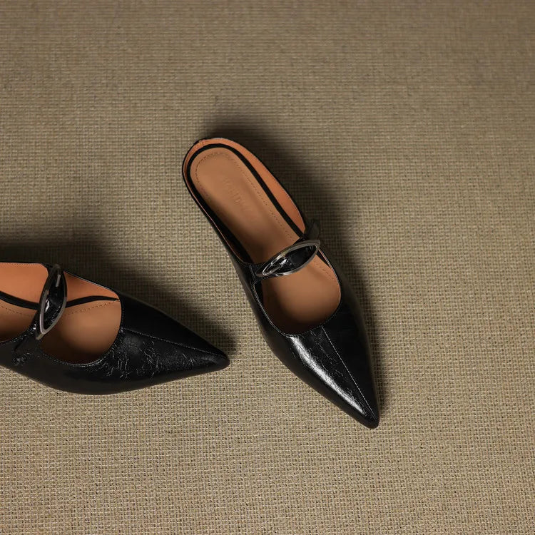 Black leather pointed-toe mules with slingback strap and silver buckle, side view
