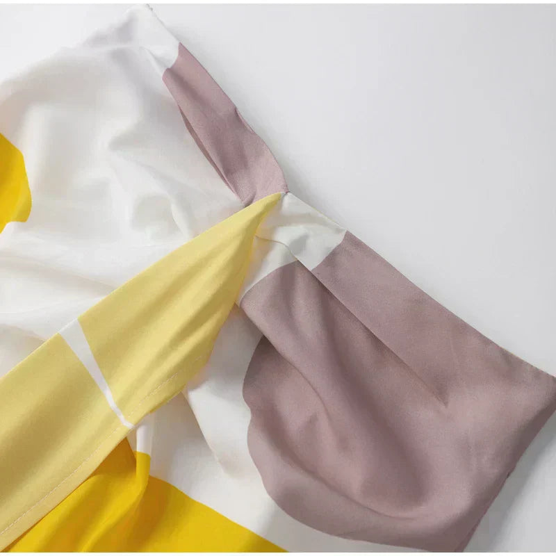 Abstract patterned top with draped dolman sleeves in white, yellow, and taupe