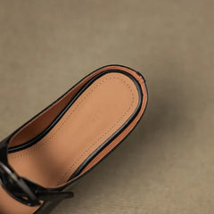 Close-up of black leather mule interior with tan lining and slingback strap