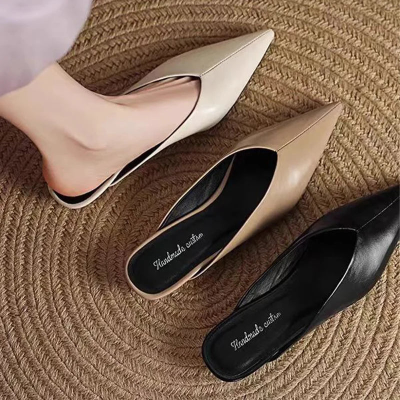 Beige leather pointed-toe mules with low heel, slip-on style.