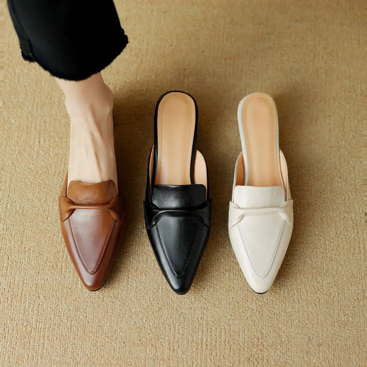 Leather mules in brown, black, and white with pointed toe and low block heel.