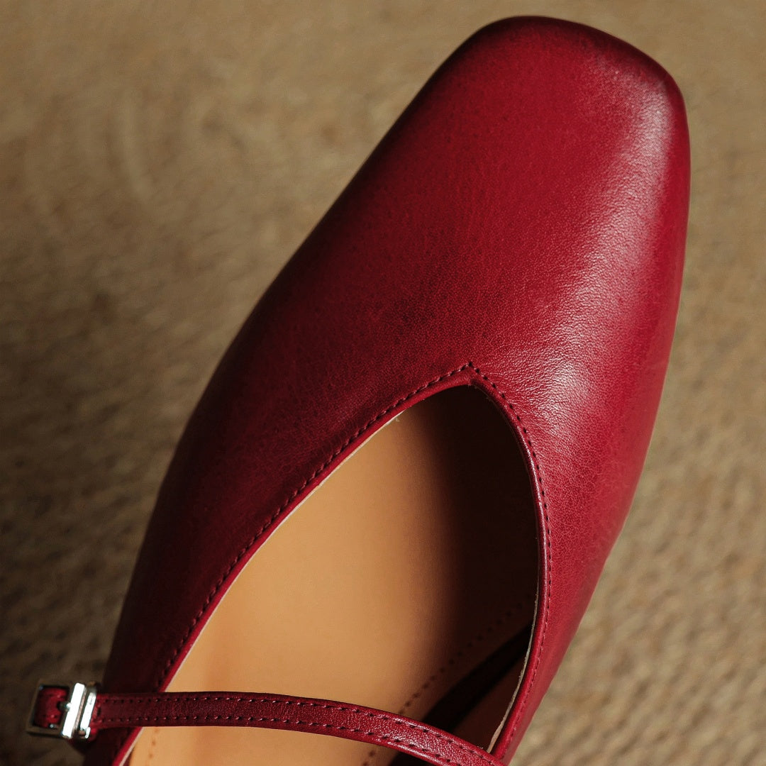 Maroon leather mule upper close-up with cutout opening and strap buckle