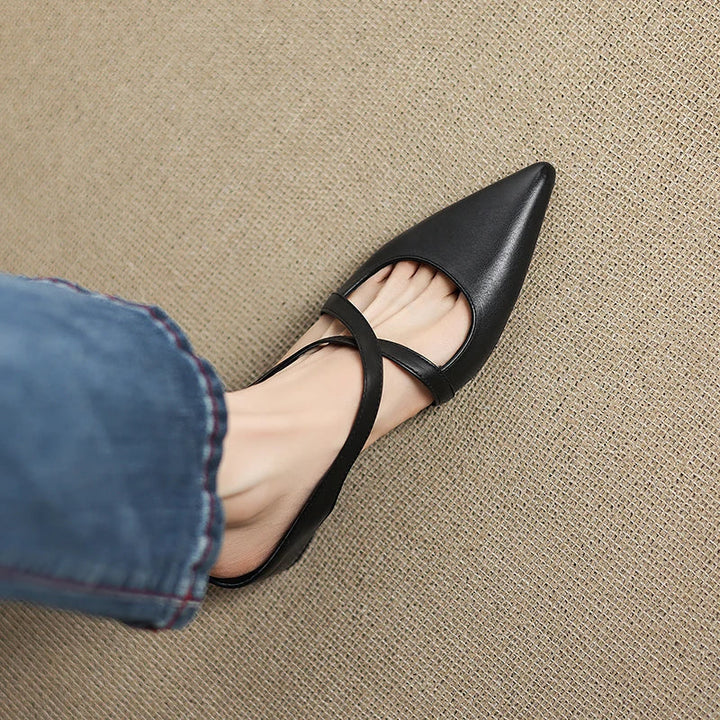 Black pointed-toe mule with T-strap slingback and low block heel, close-up