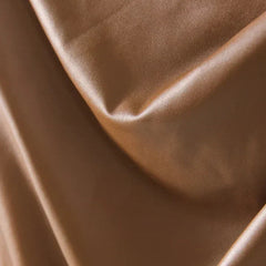 Close-up of bronze-brown leather with soft folds and smooth sheen
