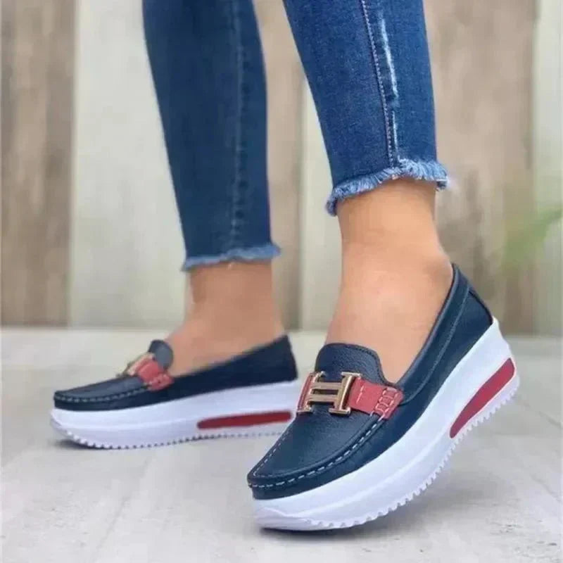Sleek orthopedic loafers, dark blue slip-on with buckle strap and red accent.