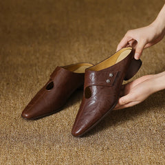 Brown leather mules pair with side cutouts and stud accent, low heel
