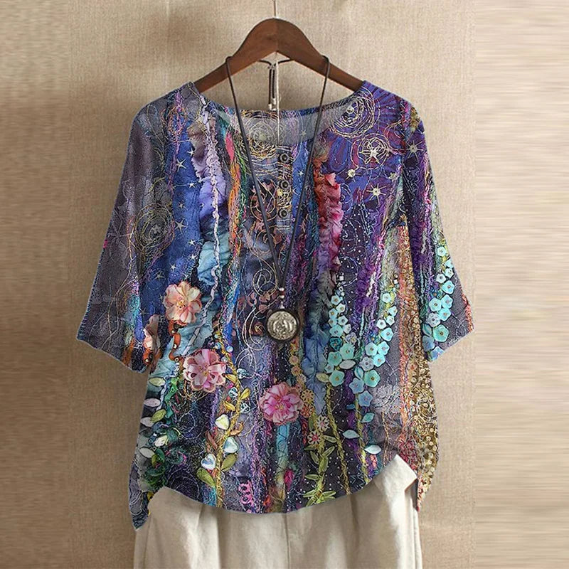 Women’s colorful floral blouse, deep purple with layered floral and ornament pattern, short sleeves.