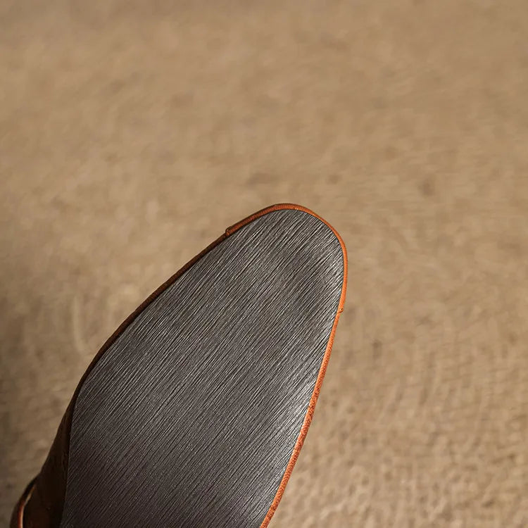 Brown leather mule outsole view with textured tread and orange trim edge