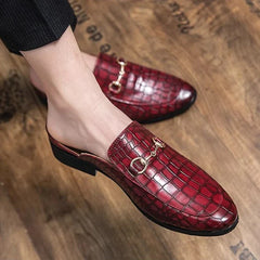 Red croc-textured leather mules, close-up of metal buckle strap and black sole