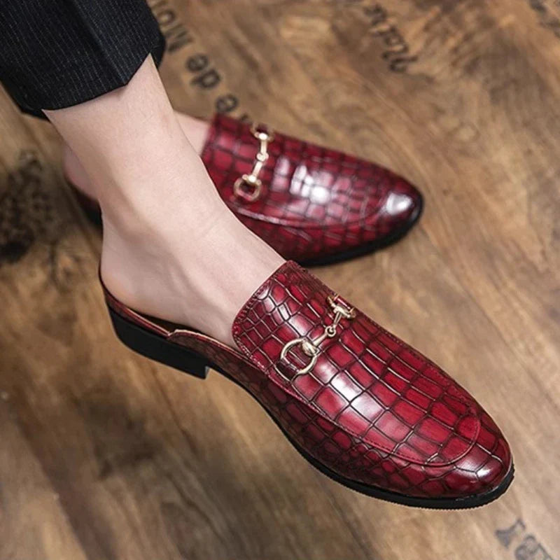 Red croc-textured leather mules, close-up of metal buckle strap and black sole