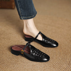 Black leather mule with braided vamp, sling strap, and round gold buckle
